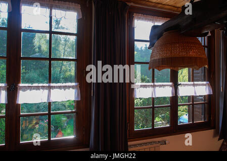 Garden and trees seen through the windows of a mountain lodging, Jura, France Stock Photo