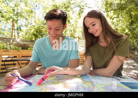 Image of concentrated young multiethnic friends students outdoors studying and talking with each other. Looking aside. Stock Photo