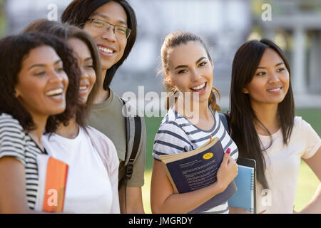 Picture of multiethnic group of young happy students standing outdoors. Stock Photo