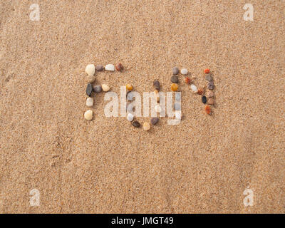 word fun written with stones and shells on the beach by the ocean Stock Photo