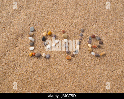 word love written with stones and shells on the beach by the ocean Stock Photo