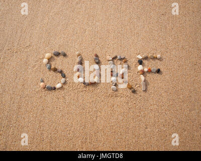 word surf written with stones and shells on the beach by the ocean Stock Photo