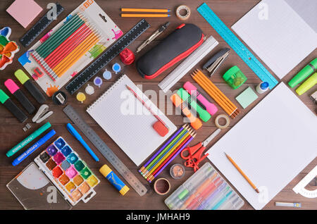 lot of school supplies tools equipment on a desk - pencils, pens, notepads, exercise book, copybook, ruler, pencil case, paints, sharpener. back to sc Stock Photo