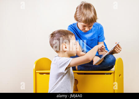 Children playing on tablet at home Stock Photo
