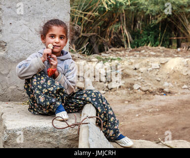 Leh, Ladakh, India, July 14, 2016: young girl is playing with a necklace near her house in Leh, India Stock Photo