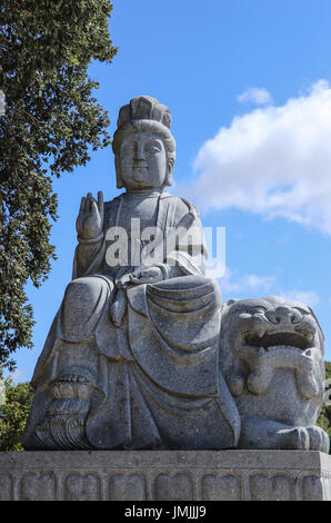 Stone statue of buddha in a zen garden Stock Photo