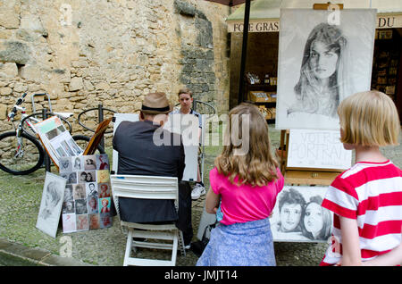 Street artist sketching portraits in Sarlat, France Stock Photo