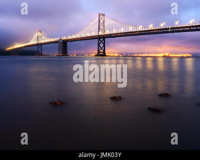 New Bay Bridge at Night with Reflected Lights off of the San Francisco Bay as Seen from the Embarcadero, San Francisco, California Stock Photo