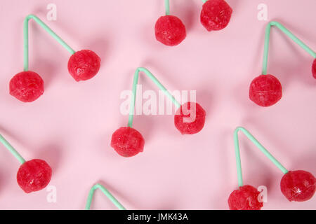 lot of Twin Cherry Lollipops like an old time ago on a pink background with blur effect. Minimal color still life photography Stock Photo