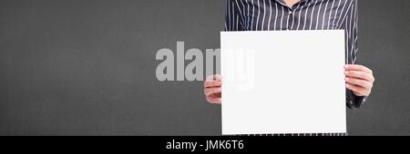 Digital composite of Business woman holding a blank card against grey background Stock Photo
