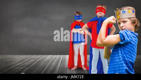 Digital composite of Superhero kids and king crown boy with blackboard background Stock Photo