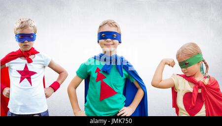Digital composite of Superhero kids with blank grey wall Stock Photo
