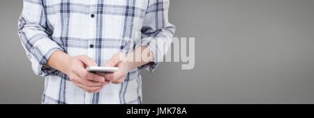 Digital composite of Man using a phone against grey background Stock Photo