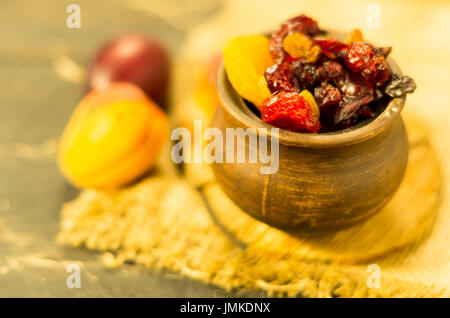 Dried fruits in a clay pot. Rural style. Warm mood. Stock Photo