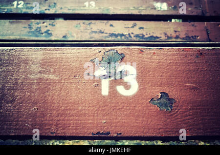 Number thirteen painted on an old wooden seat, conceptual picture. Stock Photo