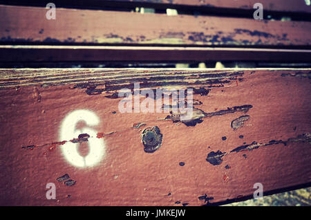 Number six painted on an old wooden seat, conceptual picture with copy space on the right. Stock Photo