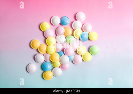 flying saucer multi coloured candy sweets on a gradient background pink and blue. Minimal color still life photography Stock Photo