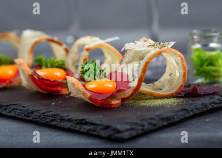 Tapas on Crusty Bread - Selection of Spanish tapas served with a sliced baguette. Stock Photo