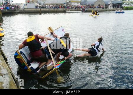 West Bay, Dorset, UK.  27th July 2017.  Annual RNLI Raft Race on the River Brit at the seaside resort of  West Bay in Dorset.  One of the rafts capsizes.  Picture Credit: Graham Hunt/Alamy Live News Stock Photo
