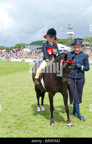 Llanelwedd, Powys, UK. 27th July, 2017. Seven-year-old Ella Eyenon takes reserve prize in the 'Supreme Champion Ridden Horse' event on the last day of the Royal Welsh Show. The Royal Welsh Agricultural Show is hailed as the largest & most prestigious event of its kind in Europe. In excess of 200,000 visitors arrive for the four day show period. The first ever show was at Aberystwyth in 1904 and attracted 442 livestock entries. Credit: Graham M. Lawrence/Alamy Live News