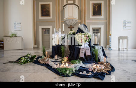 Flowers and candles are seen on a place of remembrance for the victims