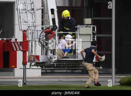 Haikou, China's Hainan Province. 28th July, 2017. People attend a high-rise building fire drill in Haikou, capital of south China's Hainan Province, July 28, 2017. Credit: Yang Guanyu/Xinhua/Alamy Live News Stock Photo