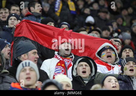 LVIV, UKRAINE - FEBRUARY 17, 2015: People watch the football game at Arena Lviv stadium during UEFA Champions League game between Shakhtar Donetsk and FC Bayern Munich Stock Photo