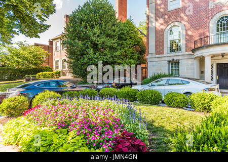 Washington DC, USA - June 29, 2016: Embassy row with three Tesla Model S cars parked outside on Massachusetts avenue street with garden on Kalorama ne Stock Photo