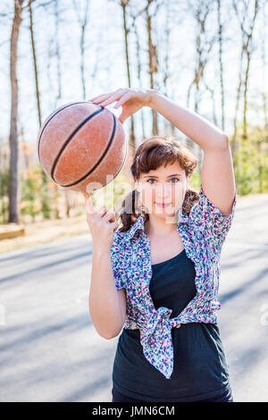 Young fit woman holding basketball in playground Stock Photo