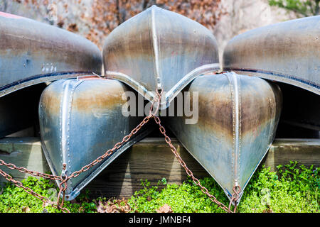 Many stacked rowing canoe boats closeup tied with chain Stock Photo