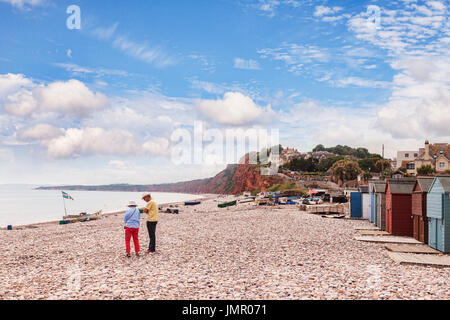 26 June 2017: Budleigh Salterton, East Devon, England, UK - Senior couple on the pebble beach at Budleigh Salterton, on a bright summer day with blue  Stock Photo