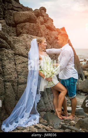Newly married couple by the sea on their wedding day Stock Photo