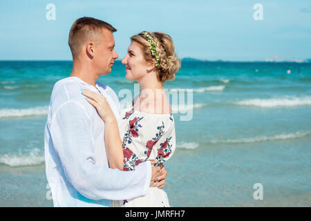 Happy young couple laughing and hugging on the beach Stock Photo