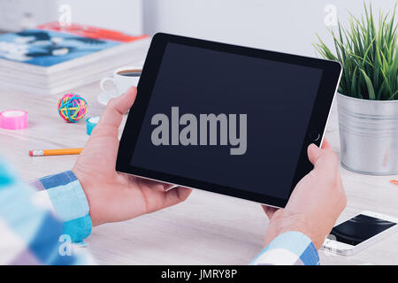 Young man using tablet computer at the office workplace. Stock Photo