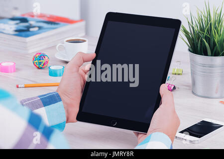 Young man using tablet computer at the office workplace. Stock Photo