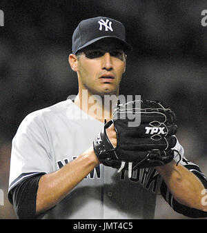 New York Yankees pitcher Andy Pettitte holds his glove to his face as he  sizes up a hitter in the sixth inning of the Yankees 8-3 victory over the  New York Mets