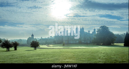 Lincolnshire's Burghley House taken on a cold early Autumnal morning, sunrise in the background and morning dew on the lawns. Stock Photo
