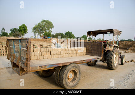 AMRITSAR, PUNJAB, INDIA - 21 APRIL 2017 : bricks being loaded on a truck by a worker ready for dispatch to a wholesale market Stock Photo