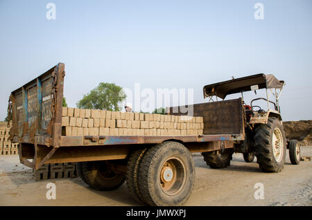 AMRITSAR, PUNJAB, INDIA - 21 APRIL 2017 : bricks being loaded on a truck by a worker ready for dispatch to a wholesale market Stock Photo