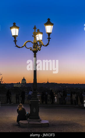 tourists looking at st peter´s basilica at dusk, seen from pincian hill in villa borghese gardens, rome, lazio, italy