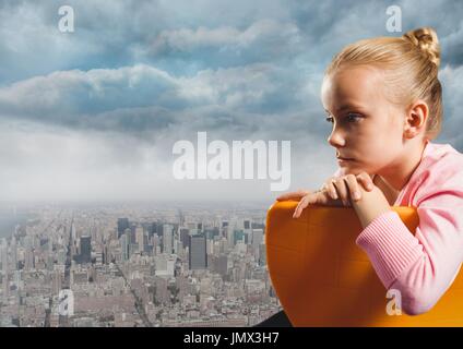 Digital composite of Girl sitting contemplative in chair over city Stock Photo