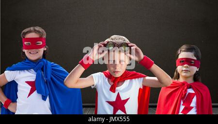 Digital composite of Superhero kids in front of blackboard Stock Photo
