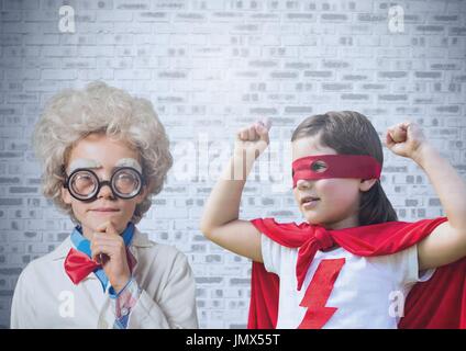 Digital composite of Superhero and scientist kids in front of brick wall Stock Photo