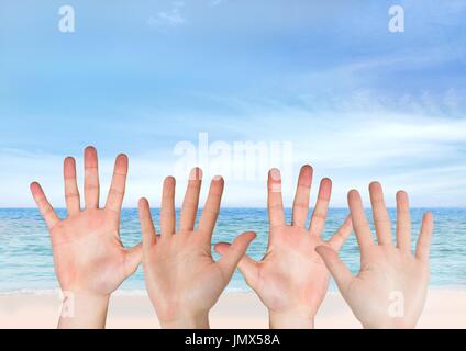 Digital composite of Four hands open in front of the sea Stock Photo