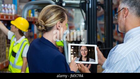 Digital composite of Man and woman video conferencing with colleague Stock Photo