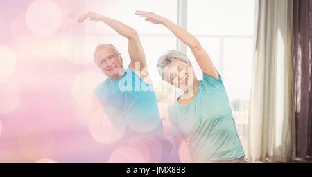 Digital composite of Senior man and woman exercising with bokeh in foreground Stock Photo