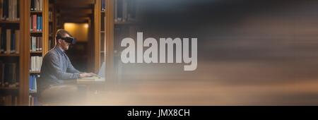 Digital composite of Man in virtual reality headset in library and blurry sunset transition Stock Photo