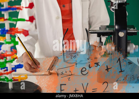 IllustrationÃ‚Â of algebraic formulas against schoolboy writing on book against green background Stock Photo