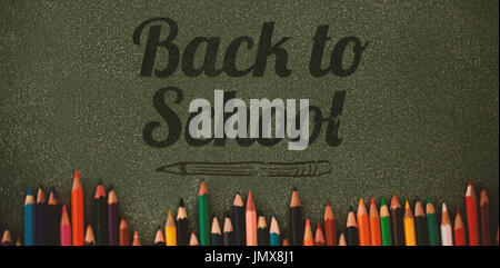 Back to school text over white background against overhead view of colored pencils on gray table Stock Photo
