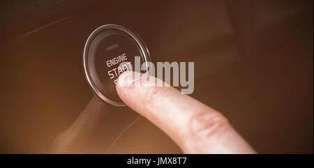 Cropped finger pressing start button in car Stock Photo